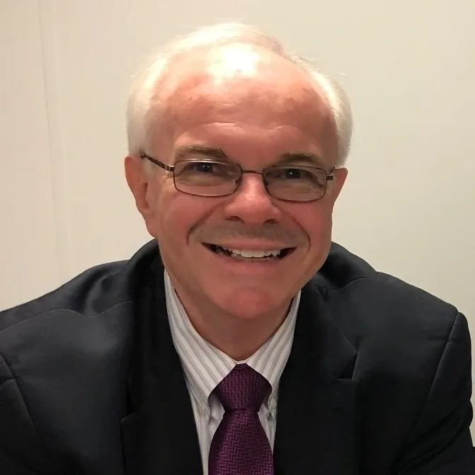 Smiling elderly man in a suit and tie.