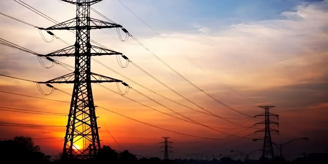 Power lines stretch across a colorful sunset sky.