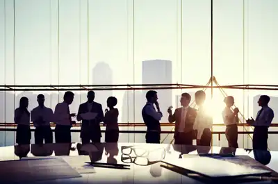 Silhouetted professionals networking in a modern office at sunset.